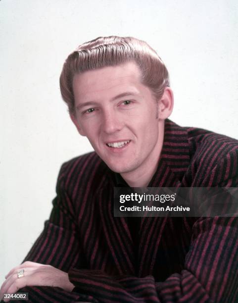 Promotional studio headshot portrait of American rock n' roll singer and pianist Jerry Lee Lewis wearing a striped blazer.
