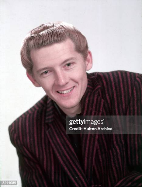 Promotional studio headshot portrait of American rock n' roll singer and pianist Jerry Lee Lewis wearing a striped blazer.