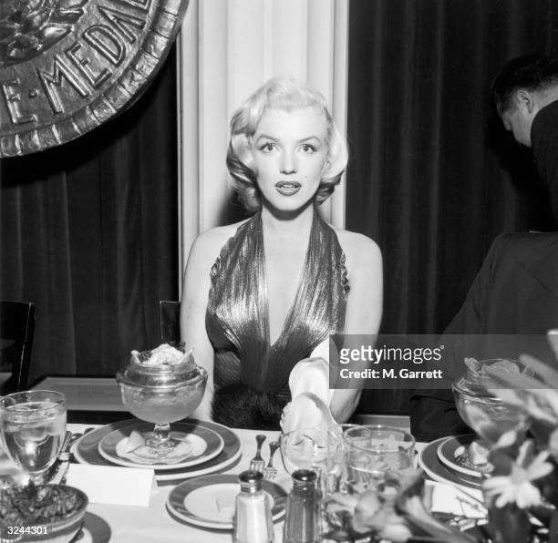American actor Marilyn Monroe sits at a banquet table during a Photoplay Gold Medal Awards dinner. Monroe won two of the magazine's awards. In 1952...