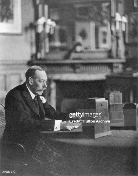 George V , King of Great Britain preparing to give a radio broadcast from a room at Sandringham.