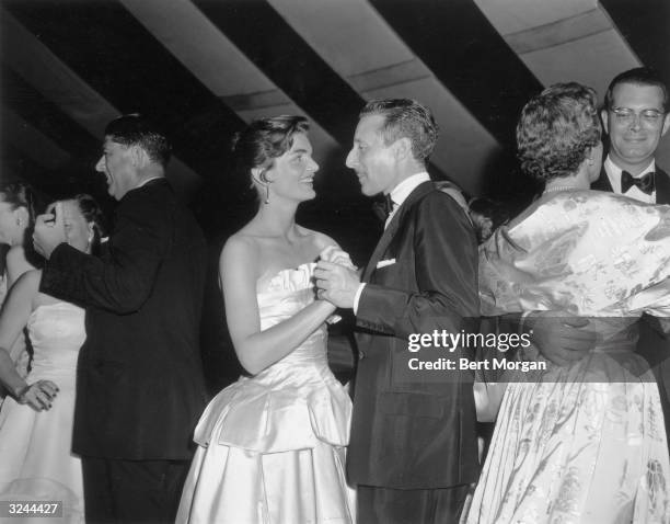 Jacqueline Kennedy , the wife of US senator John F Kennedy, dances with American fashion designer Oleg Cassini at the Belmont Ball, along with other...