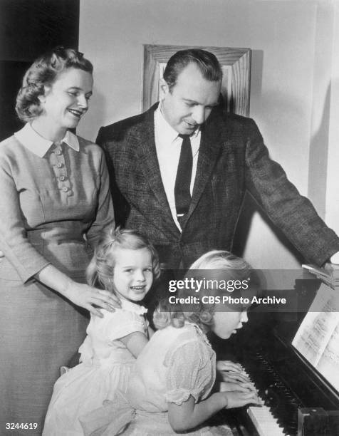 News correspondent Walter Cronkite and his wife Betty stand by a piano with their two daughters, Nancy and Mary Kathleen in their East End Avenue...