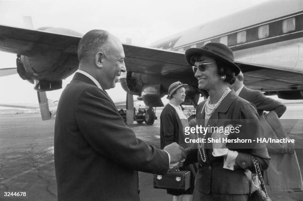 American department store executive Stanley Marcus holds hands and says goodbye to French fashion designer Coco Chanel at the airport, after her...