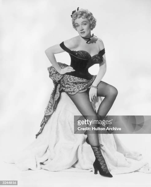 German-born actor Marlene Dietrich poses in a western saloon costume in a promotional portrait for director Fritz Lang's film, 'Rancho Notorious'.