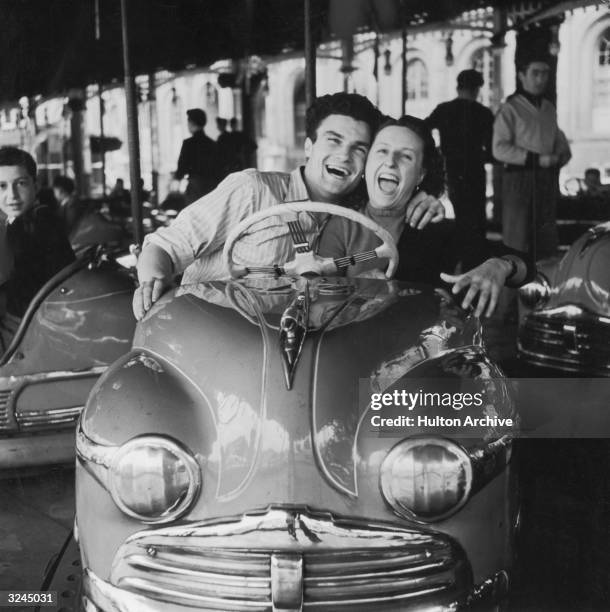 Man and woman riding in a bumper car.