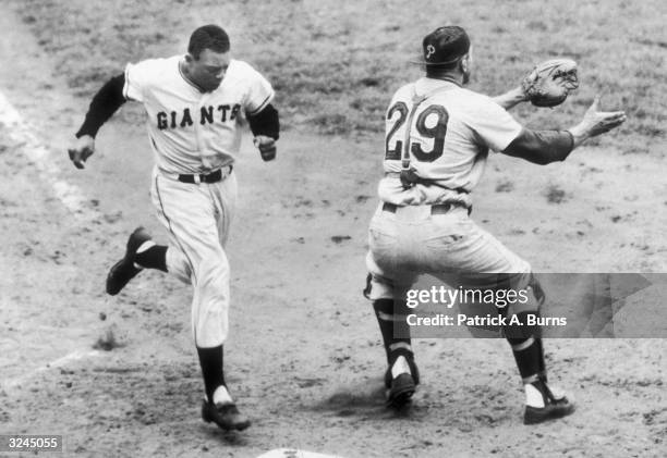 Giants baseball player Willie Mays crosses home plate after hitting a home run as Philadelphia Phillies Catcher Stan Lopata waits for the throw, Polo...