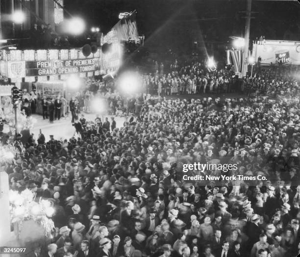 Large crowd gathered outside the Warner Brothers movie theatre on Wilshire Boulevard in Los Angeles for a night opening. The sign outside the cinema...