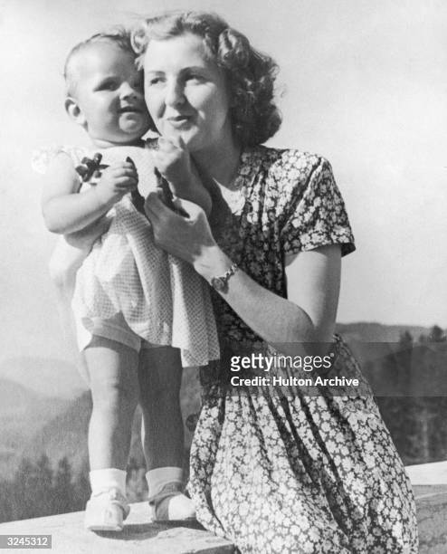 Eva Braun, the German mistress of chancellor Adolf Hitler poses on a terrace with an infant, in a still from a home movie taken by her sister Grete...