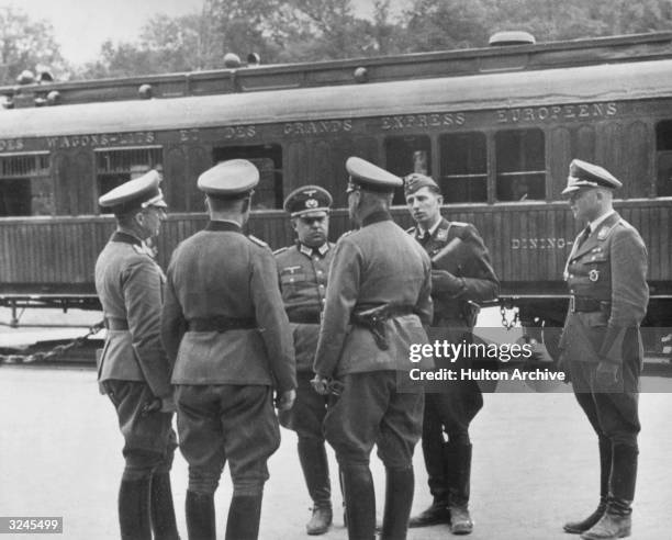 Chief of Nazi war staff General Wilhelm Keitel speaks with other uniformed German officers in front of the railway car in which France signed an...