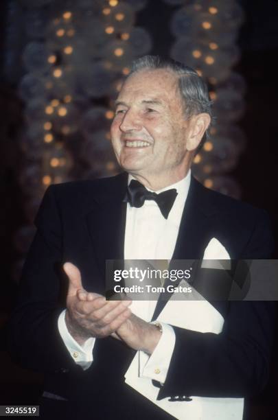 American banker David Rockefeller, wearing a tuxedo, claps at the opening of three new restaurants in Rockefeller Center, New York City.