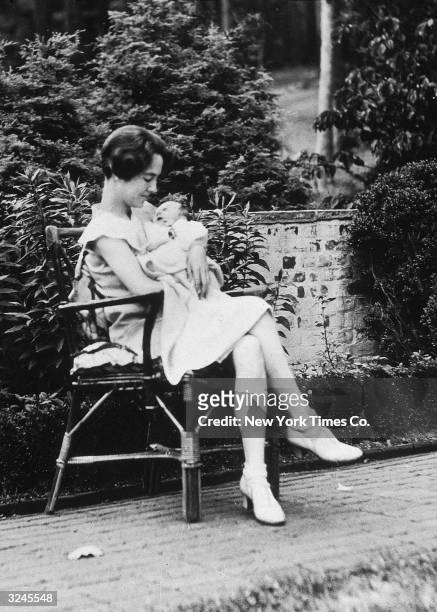 American writer Anne Morrow Lindbergh cradling her infant son, Charles Augustus Lindbergh Jr, on the Morrow estate, Englewood, New Jersey. Two years...