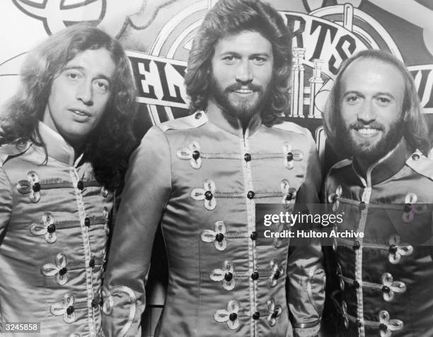 Brothers Robin, Barry and Maurice Gibb of the Australian rock and roll group the Bee Gees smile in their costumes in a promotional portrait for...