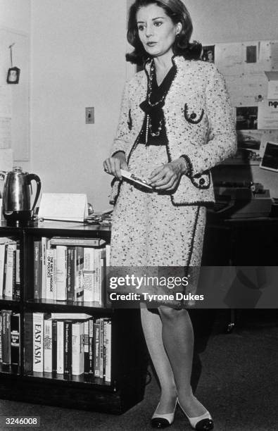 Full-length portrait of American broadcast journalist Barbara Walters, wearing a Chanel suit, standing in her office, New York City.