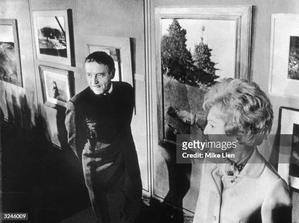 American painter Andrew Wyeth and First Lady Pat Nixon standing by a wall filled with paintings, in the East Room of the White House, Washington, DC.