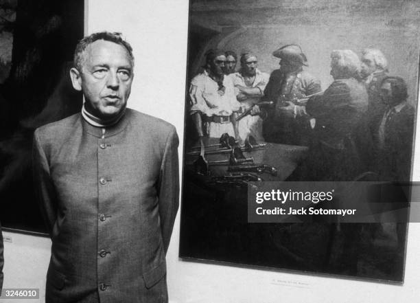 American painter Andrew Wyeth standing beside a painting, 'Serving out the Weapons' painted in 1911 by his father N C Wyeth, in the Howard Pyle and N...