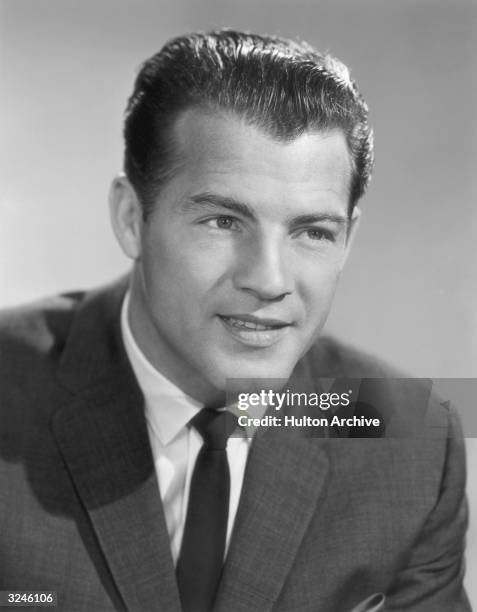 Headshot studio portrait of American football player and future sportscaster Frank Gifford in a suit and tie.