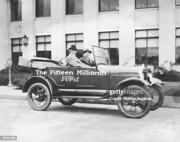 American inventor and industrialist Henry Ford and his son, automobile executive Edsel Ford , sit in 'The Fifteenth Millionth Ford'.