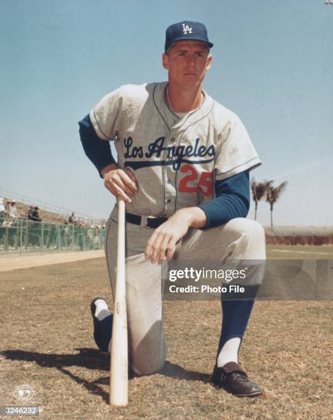 Portrait of Los Angeles Dodgers outfielder Frank Howard, kneeling and holding a baseball bat, late 1950s. He wears his uniform.