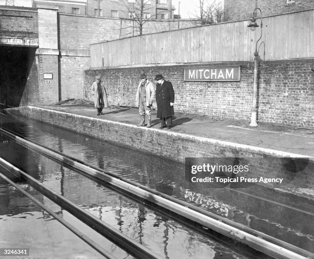 The River Wandle overflows and floods Mitcham Station in south London.