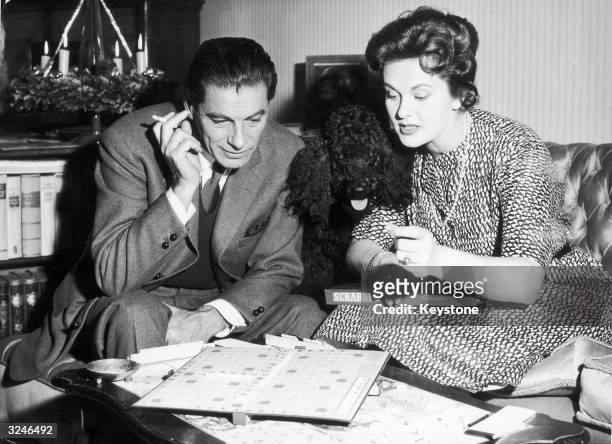 Rudolf Prack and Marianne Wischmann playing Scrabble shortly after its introduction to Germany in time for the Christmas market . Their poodle...