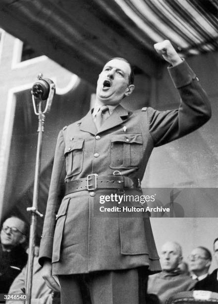 French general and statesman Charles de Gaulle raises his fist as he delivers an address at the end of the Allied Armistice Day parade in Algiers,...