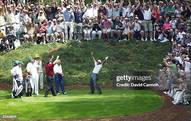 Tiger Woods of the USA celebrates a hole-in-one on the ninth hole with Arnold Palmer and Mark O'Meara during the Par 3 Contest prior to the Masters...