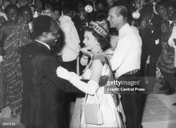 Queen Elizabeth II dances with Ghanaian president Kwame Nkrumah at a farewell ball held at State House, Accra. They, and the Duke of Edinburgh, are...
