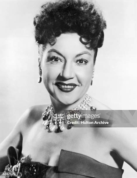 Promotional studio portrait of American actor and singer Ethel Merman , wearing a jeweled necklace and a strapless evening gown.