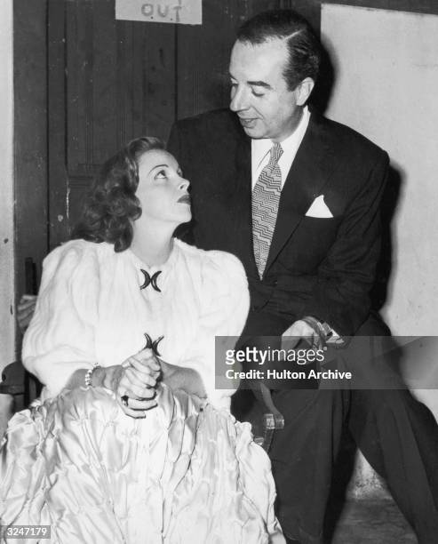 American actor Judy Garland listens to her husband, American film director Vincente Minnelli , while they sit together backstage at the Hollywood...