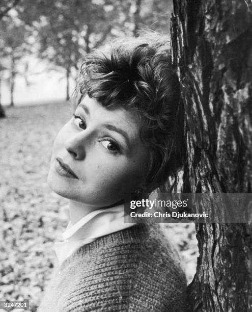 British actress Prunella Scales leaning against a tree.