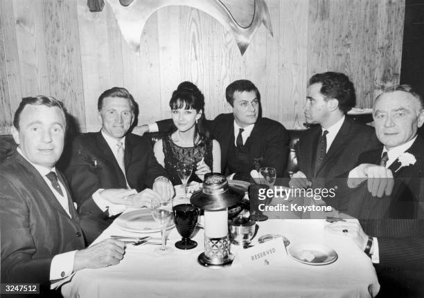 Left to right: Charles Kahn, Kirk Douglas, actress Christine Kaufmann with her husband Tony Curtis, Arthur Cohen and producer Sy Bartlett dining out...
