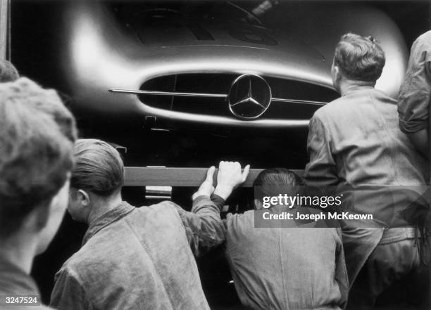 Mechanics examine Juan Manuel Fangio's W196 Mercedes Benz in the pits at the French Grand Prix in Reims, 4th July 1954. Original Publication: Picture...