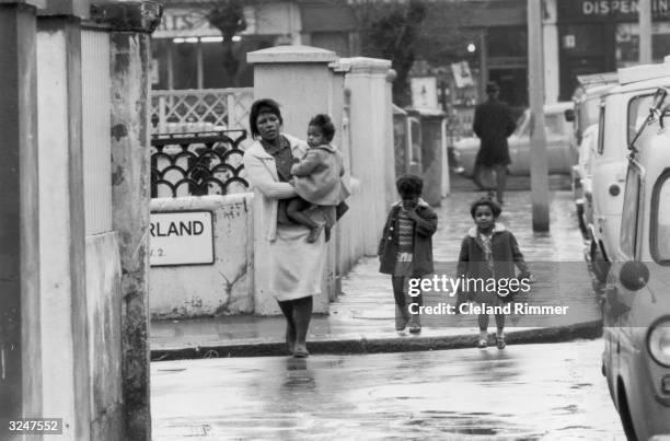 West Indian woman and her three children walk down a street in London's Notting Hill.