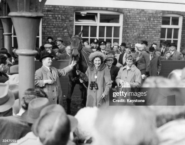 Mr Bigg and his wife, owners of the Grand National winner Oxo, lead the horse to the paddock after its victory at Aintree in Liverpool.