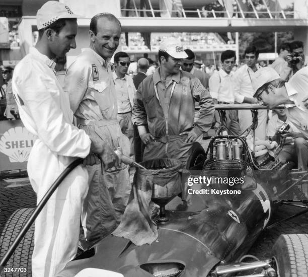 Members of the Ferrari crew refuel New Zealand racing driver Chris Amon's Ferrari 312 during the Italian Grand Prix at Monza.