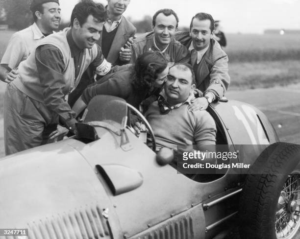 Jose Frolien Gonzalez is kissed by his wife after winning the British Grand Prix at Silverstone in his Ferrari 375.