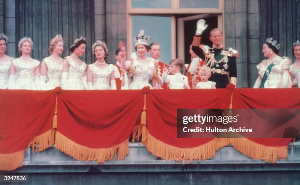 The Duke of Edinburgh and the newly crowned Queen Elizabeth II wave to the crowd from the balcony at Buckingham Palace. Her children Prince Charles...