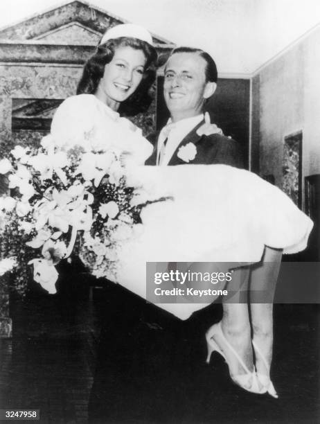 Baron Hans Heinrich von Thyssen-Bornemisza carries his new bride, British fashion model Fiona Campbell-Walter, over the threshold of his villa at...