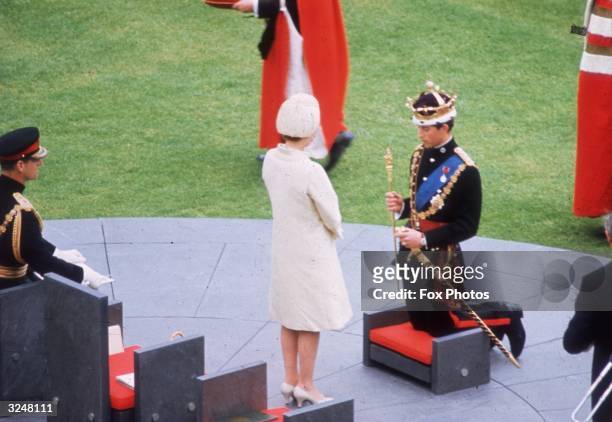Queen Elizabeth II crowns her son Charles, Prince of Wales, during his investiture ceremony at Caernarvon Castle.