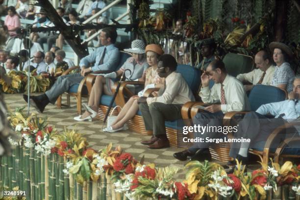 Queen Elizabeth II and Prince Philip pay an official visit to the Cook Islands, accompanied by Princess Anne and Mark Phillips.