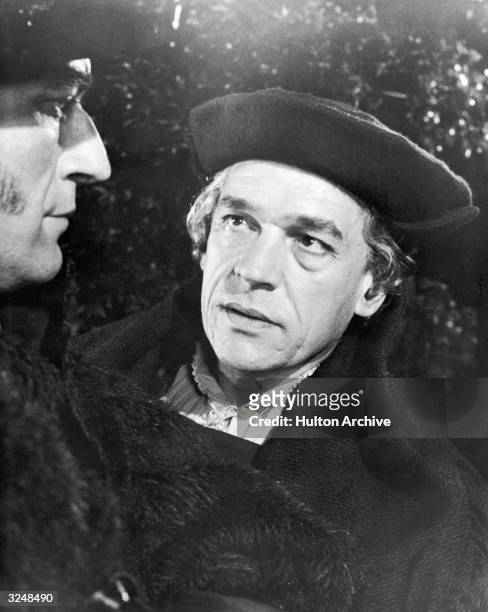 British actor Paul Scofield speaks to another actor in a still from the film, 'A Man for All Seasons,' directed by Fred Zinnemann.