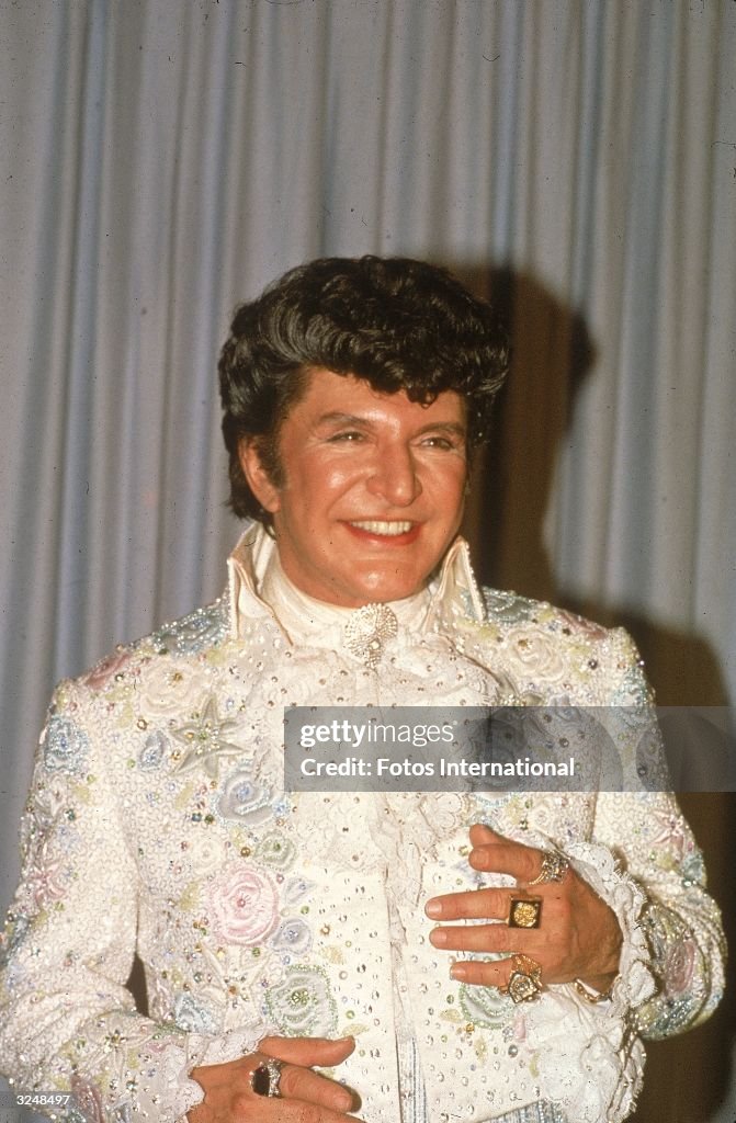 Liberace Ruffle American pianist and entertainer Liberace smiles in a sequined jacket ...
