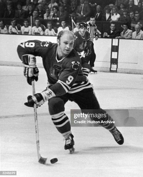 Canadian hockey player Bobby Hull, left wing for the Chicago Blackhawks, handles the puck during a game against the Montreal Canadiens.