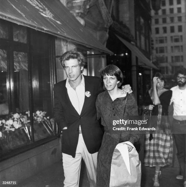 American actor Harrison Ford and wife, Mary Marquardt, walking in New York City. Filmmaker George Lucas and wife, Marcia, walk behind them.