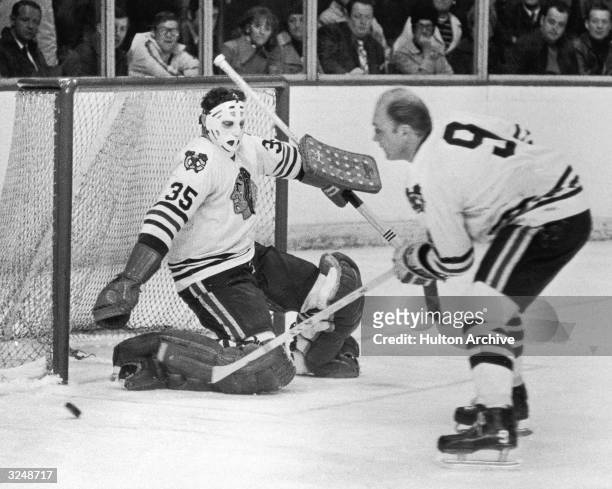 Canadian hockey players Bobby Hull, left wing for the Chicago Blackhawks, and Tony Esposito, goalie for the Montreal Canadiens, face off during a...