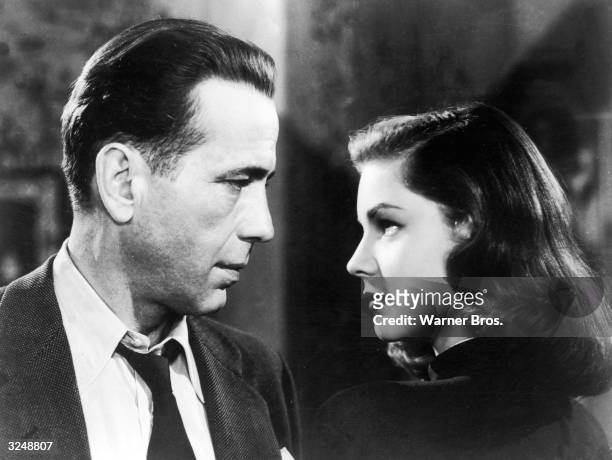American actors Humphrey Bogart and Lauren Bacall look into each other's eyes in a still from director Howard Hawks' film, 'The Big Sleep.'