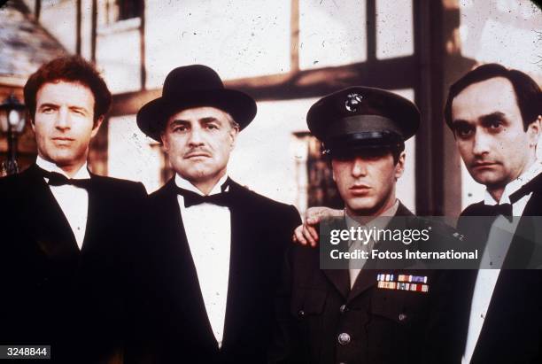 American actors James Caan, Marlon Brando, Al Pacino and John Cazale pose together outdoors in a still from director Francis Ford Coppola's film,...
