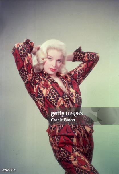 English film star Diana Dors modelling a patterned trouser-suit.