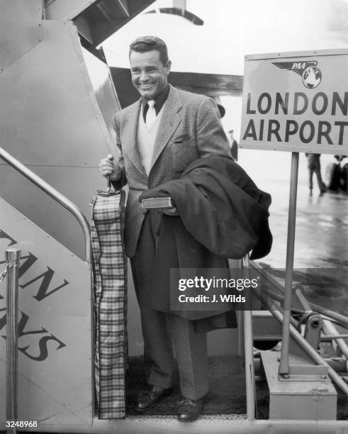 American actor Tom Neal arrives at London Airport to pay a visit to actress Barbara Payton. A year earlier, he and Franchot Tone had fought over...