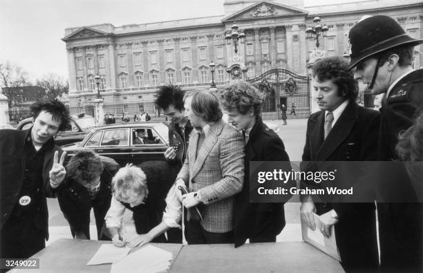 The Sex Pistols with their manager Malcolm McLaren signing a new contract with A&M Records outside Buckingham Palace, London after being dropped from...